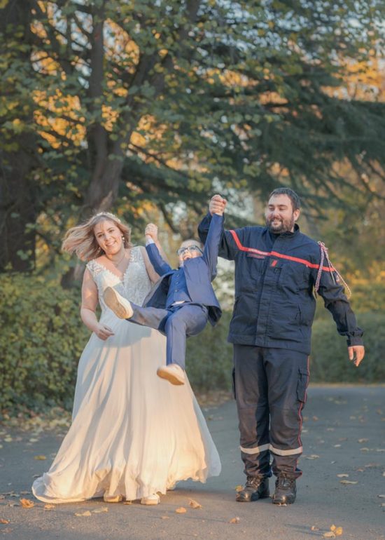 Deux parents faisant sauter leur enfant en le tenant par les mains