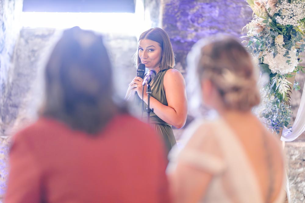 Témoin des mariées faisant un discours pendant la cérémonie et les regardant