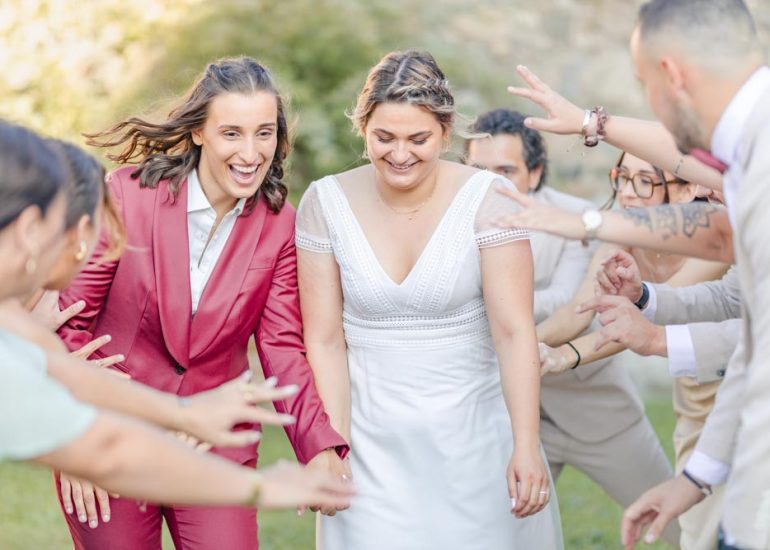 Couple souriant avançant au milieu d'une haie d'honneur à leur mariage