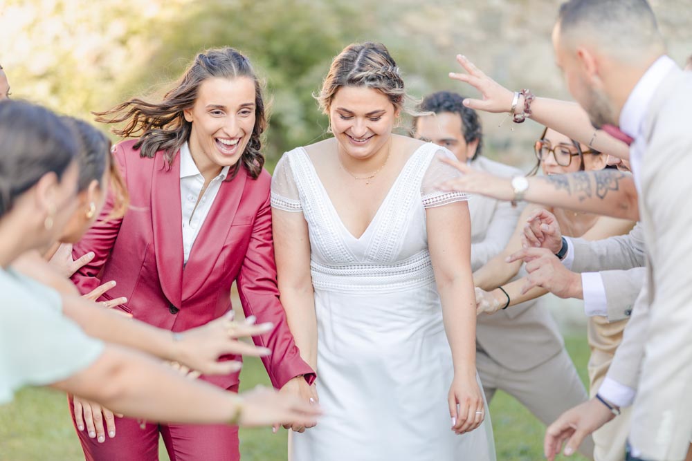 Couple souriant avançant au milieu d'une haie d'honneur à leur mariage