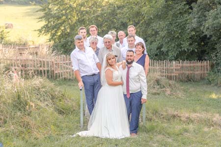 Photo de groupe d'un couple marié et de la famille posant sur un petit pont dans un parc