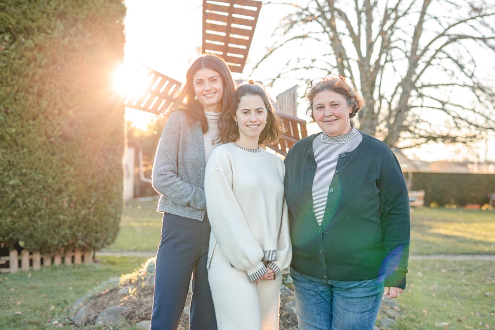 Mère et ses deux filles posant dans le jardin familial au coucher de soleil