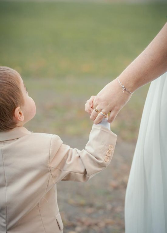 Enfant vu de dos tenant la main de sa mère