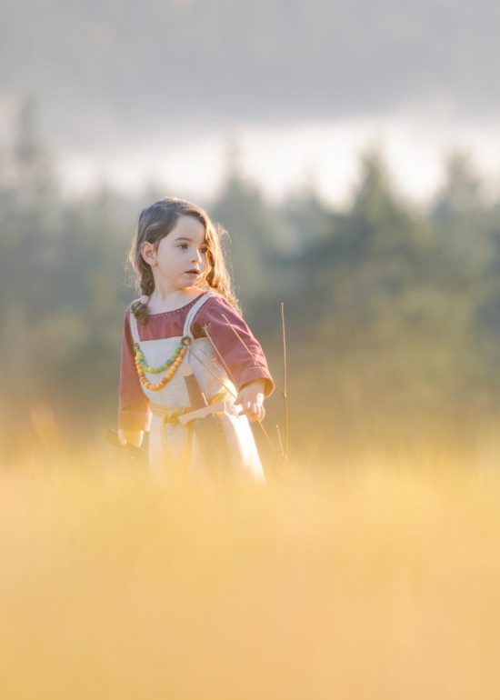 Enfant costumé en tenue traditionnelle viking dans un pré en automne