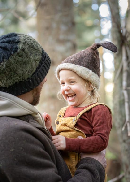 Plan serré d'une petite fille riant dans les bras de son père