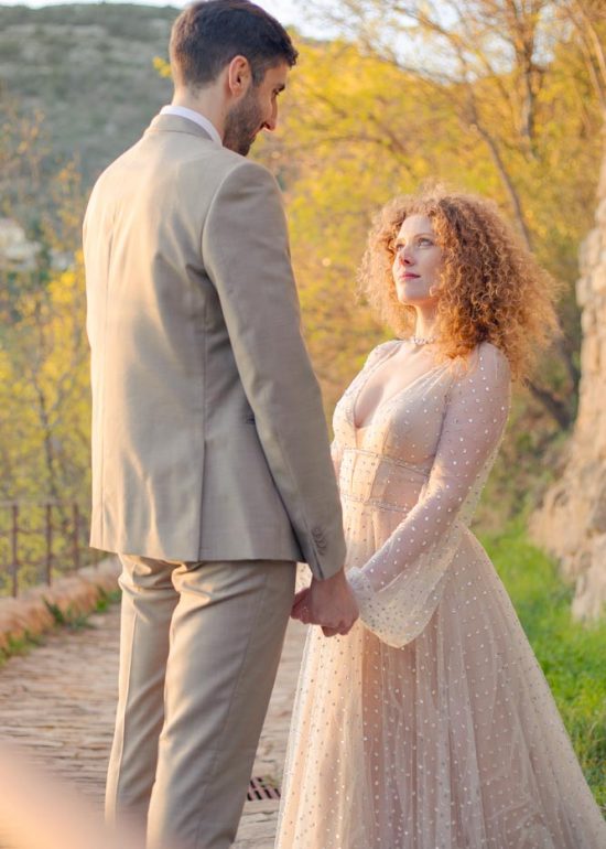 Couple se regardant et se tenant par les mains dans une allée de dalle dans la lumière de fin de journée