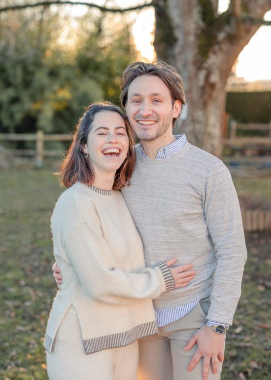 Couple en plan serré l'un contre l'autre dans le jardin familial au coucher de soleil, souriants