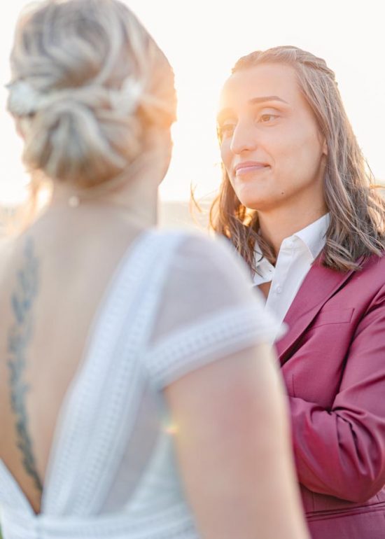 Plan serré d'un couple se regardant tendrement baigné par la lumière du soleil couchant