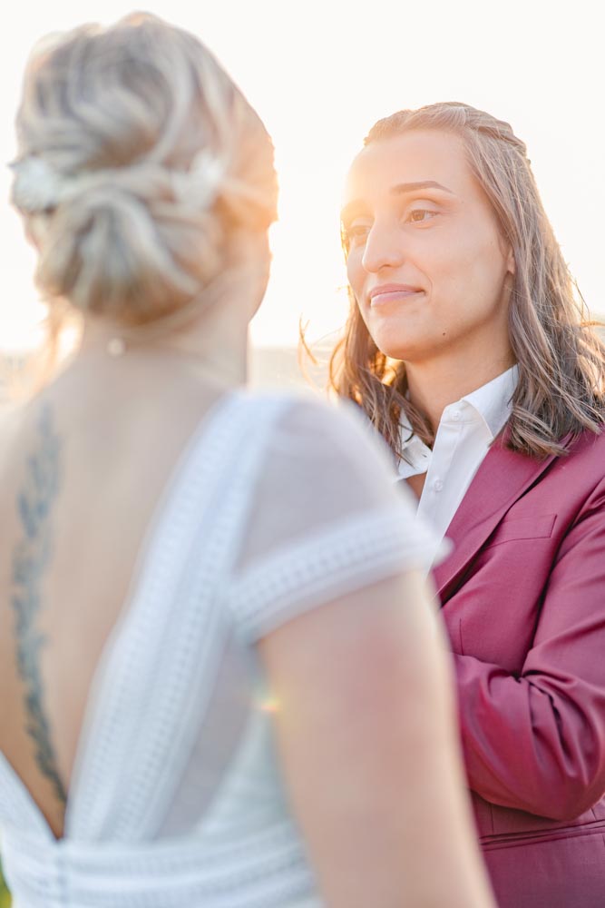 Plan serré d'un couple se regardant tendrement baigné par la lumière du soleil couchant