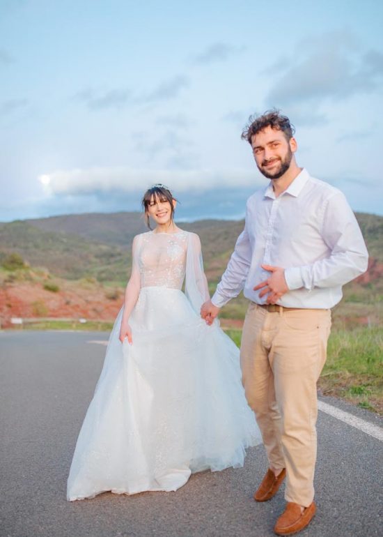 Couple souriant courant sur une route à l'heure bleue