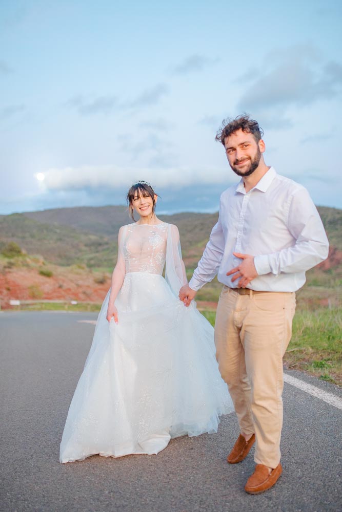 Couple souriant courant sur une route à l'heure bleue