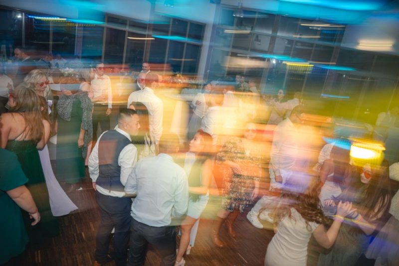 Photographie d'ambiance durant la soirée d'un mariage, avec utilisation du flash et de la technique de filé pour créer des trainées de lumières