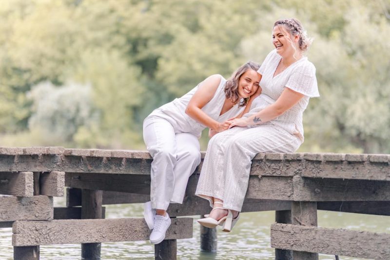 Couple assis sur un ponton et riant