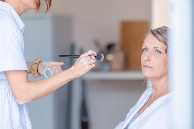 Durant les préparatifs et la séance de maquillage, la mère de la mariée regarde dehors pensive