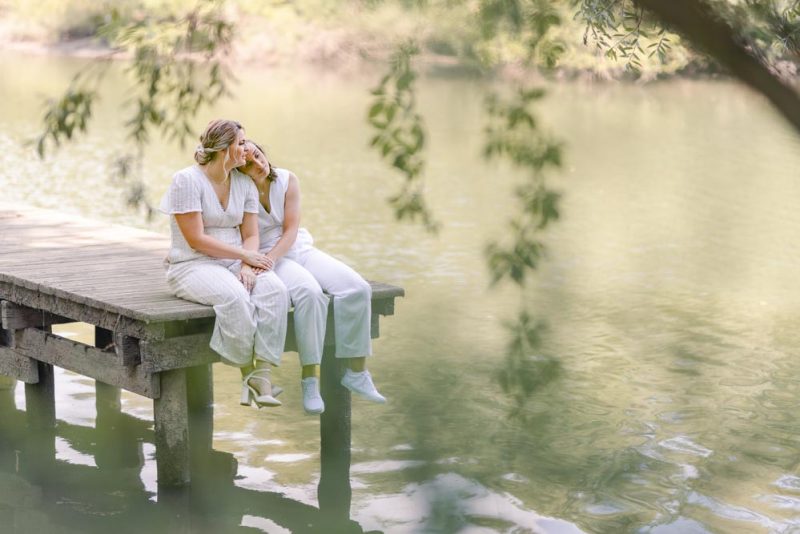 Couple assis sur un ponton, la tête reposant sur l'épaule de l'autre