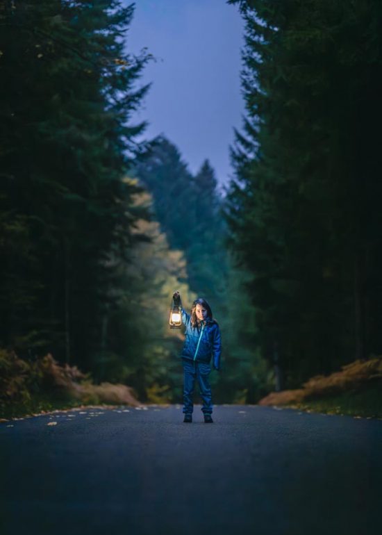 Enfant tenant une lanterne prise en photo sur une route forestière du Puy-de-Dôme