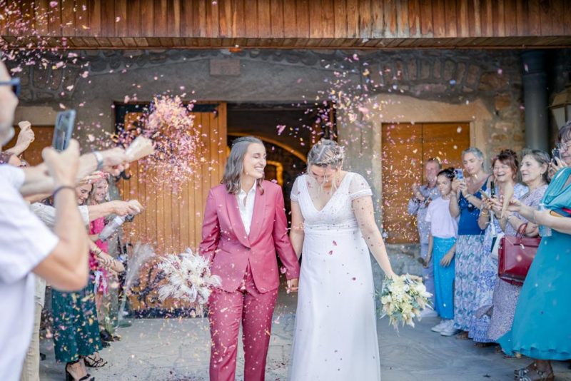 Sortie de la cérémonie des mariées avec le jeter des pétales pendant une haie d'honneur