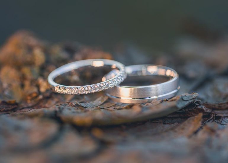 Photo en gros plan des alliances posées sur un morceau de bois