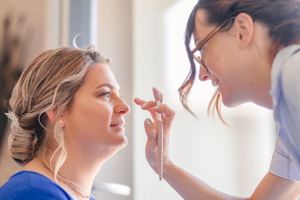 Retouches de maquillage de la mariée pendant les préparatifs