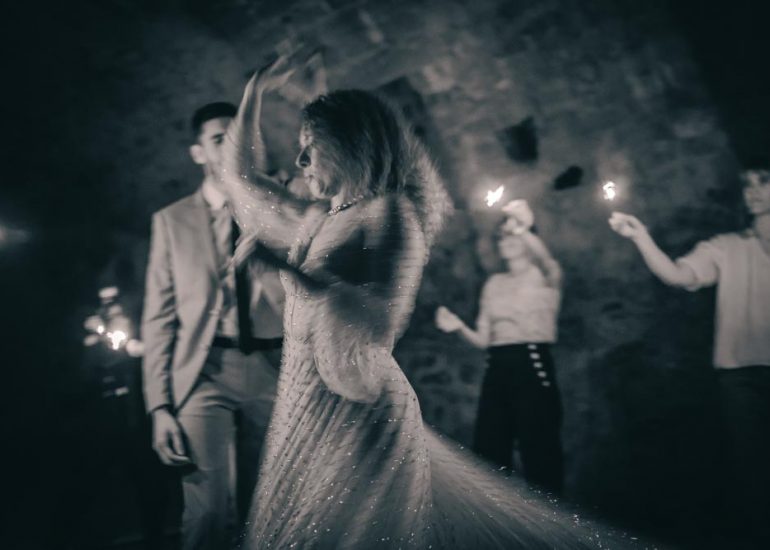 Couple dansant entourés des invités à la lumière des feux scintillants