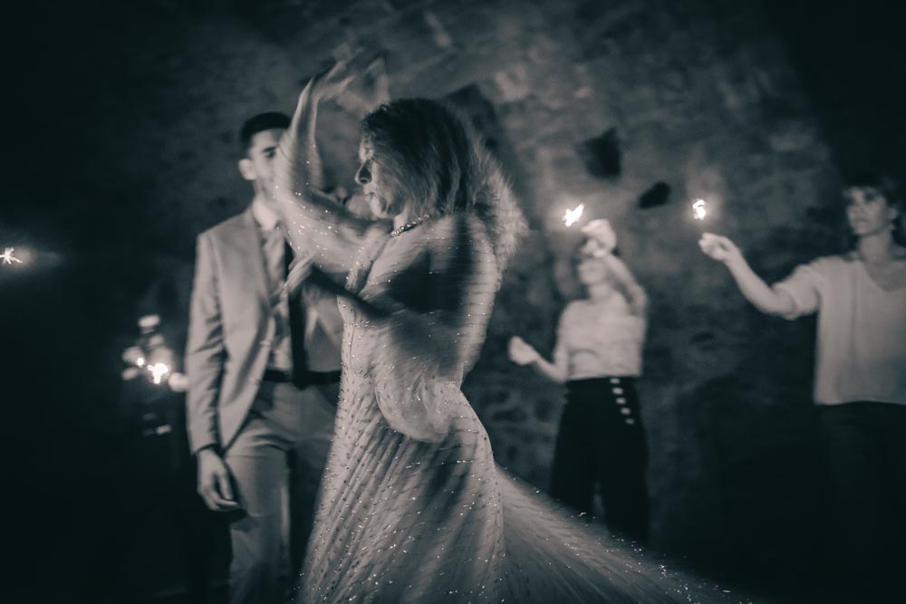 Couple dansant entourés des invités à la lumière des feux scintillants